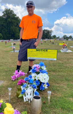 Parks and Grounds Director Chris Vaughn shows a notification sign that will be placed next to graves that violate the new Rose Cemetery rules. 