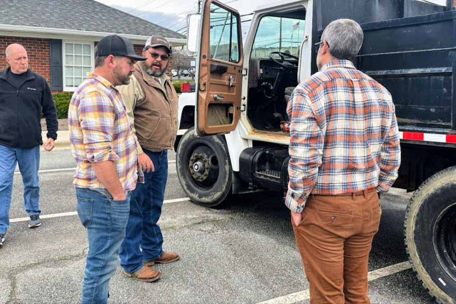 Public Works Director Brian Moore discusses the department’s dump truck with (L to R) Commissioner Rob Taylor, Commissioner Justin Draughn, and Mayor Will Marklin. 
